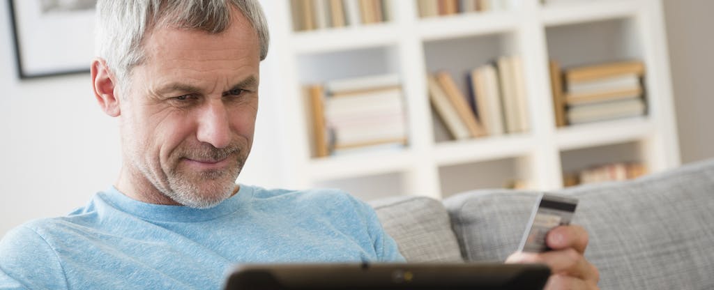 Man shops online with a digital tablet