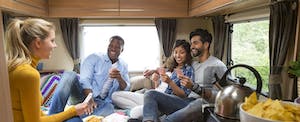 Group of friends having fun and playing cards in an RV.